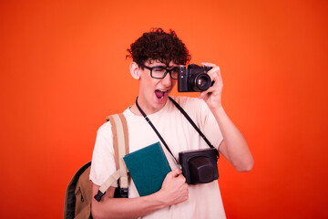Vacations and holidays. Funny lost tourist with a backpack. Orange background.