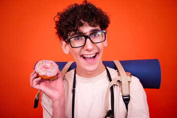 Vacations and holidays. Funny lost tourist with a backpack. Orange background.