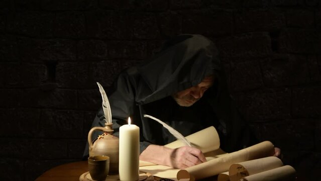 An elderly monk writes on parchment with a quill pen, dark tonality.