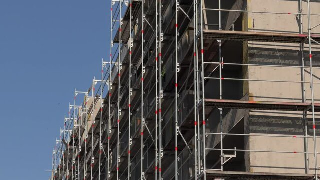 Construction exterior scaffolding. Wide angle video with a big building scaffolding for an under construction residential apartment. Construction industry 4k video.