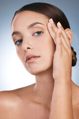 Naklejka premium Woman, portrait and skincare in studio, soft and cosmetics to pamper on blue background. Female person, makeup and transformation or facial treatment for glow, dermatology and smooth or clear skin
