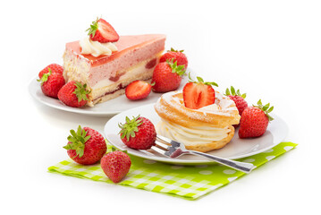 A piece of cake with strawberry souffle, custard cake with buttercream, and fresh strawberries on a green napkin. Isolate on a white background