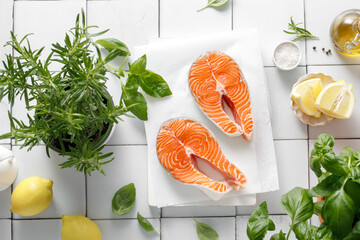 Fresh salmon steaks with herbs and ingredients for cooking, top view
