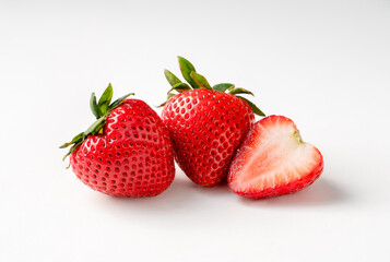macro of three strawberries on a white background