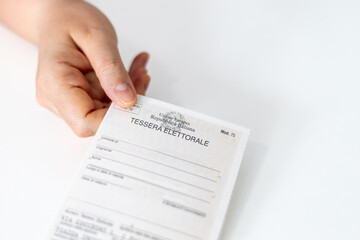 Hand of a voter holding an Italian Electoral Card (Tessera Elettorale)
