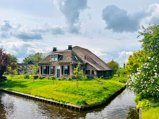 Obraz premium Thatched roof homes by the canals in the famous Giethoorn village in the Netherlands during summer
