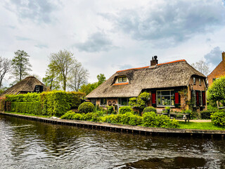 Obraz premium Thatched roof homes by the canals in the famous Giethoorn village in the Netherlands during summer