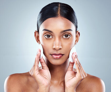 Portrait, Indian woman and skincare or cleansing, cotton pads and pamper for white background. Cosmetology, studio or hygiene routine for spot control, retinol or hyaluronic acid for female person