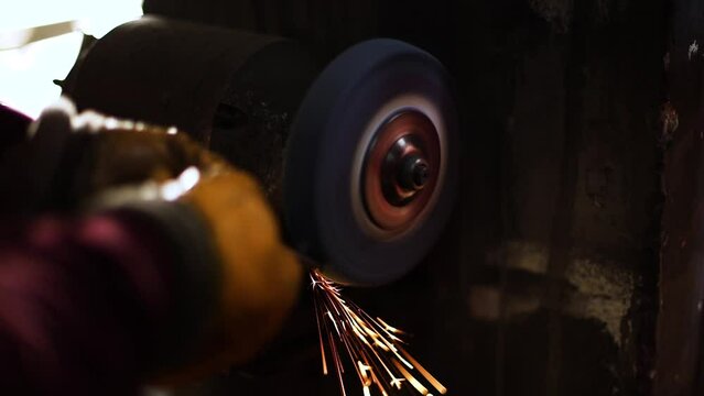 Industrial professional worker grinding metal. Sparks fly from hot metal. Slow motion.
Craftsman use saw cutting machine to cut metal detail. Man with circular saw sawing steel in garage or workshop. 