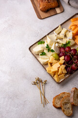 Cheese plate with different cheese, grapes and melon.