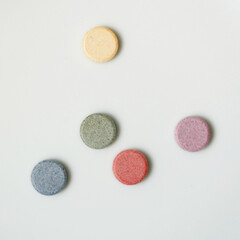 pile of pills with different pastel color on white surface
