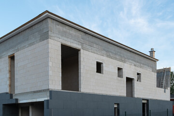 The new house construction process involves insulating the walls with modern thermal insulation materials. Exterior covering is applied at the construction site.