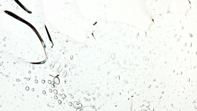 Bubble cluster, cells under a microscope. Transparent cosmetic gel fluid with molecule bubbles oil distribution. Macro Shot of Natural Organic Cosmetics, Medicine. Production Close-up. Slow Motion. 4k