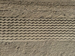 Tyre tracks were imprinted in the fine gravel of the sand
