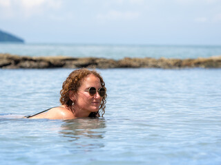 Woman Swimming in Calm Ocean Water on a Sunny Day