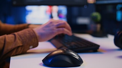 Focus on computer peripherals used by programmer to write lines of code on PC screen. Close up shot...