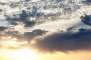 Serene sunset sky with fluffy clouds and a radiant sun