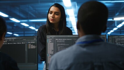 Manager in data center talking with employees about annual system review after checking parameters...