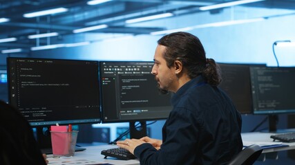 Knowledgeable engineer upgrading equipment in data center, zoom in shot. Specialist at PC desk in...