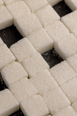 white square sugar on a black background