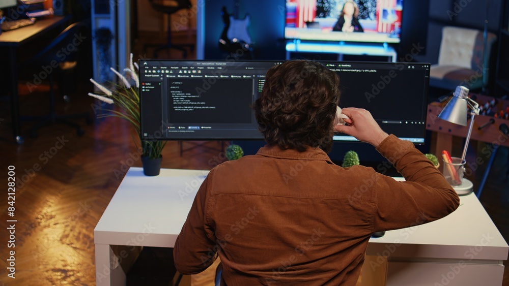 Poster computer scientist at home office desk writes binary code scripts and drinks from mug of coffee. it 