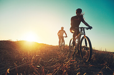 Sunset sky, people and friends on bicycle with exercise, race and adventure trail in nature...