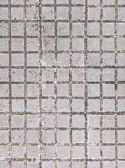 Top view of street pavement of small grey square concrete tiles texture or background. Current non-slip hydraulic exterior sidewalk of towns and cities on Mallorca island, Balearic Islands, Spain.