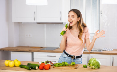 Young carefree good mood girl wearing casual clothes have fun in kitchen singing song with bell...