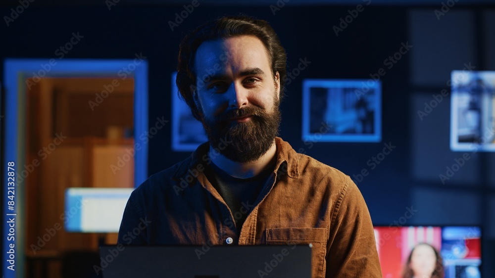 Aufkleber portrait of happy man doing it support job from apartment, standing in personal office with laptop i