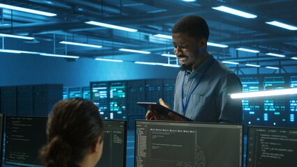 IT expert in server hub ensuring valuable data remains shielded from potential threats using...