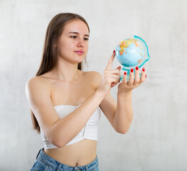 Portrait of a young student girl with a globe in her hands