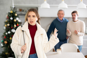 Dissatisfied young woman leaves her husband and father during Christmas celebration