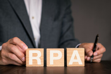There is wood cube with the word RPA. It is an abbreviation for Robotic Process Automation as...