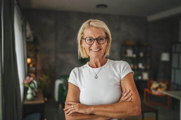 Portrait of relax mature senior woman stand and smile at home - Powered by Adobe
