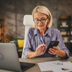 Mature senior woman work from home and use mobile phone