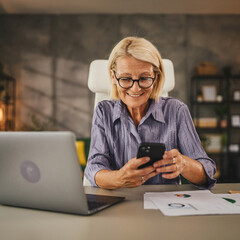 Mature senior woman work from home and use mobile phone