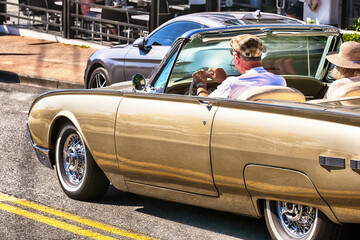 Retired couple cruise forward in their lives in a vintage American classic car.