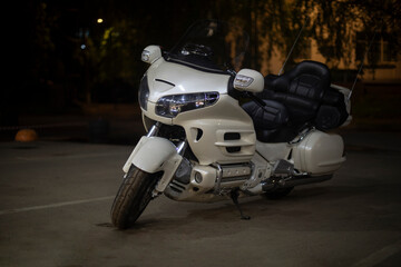 White motorcycle in the parking lot. Motorcycle at night. Personal transport.