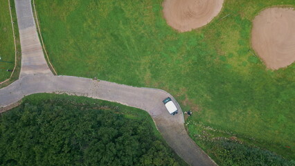 Aerial golf cart standing on winding path of lush green fairway. Golf course © stockbusters