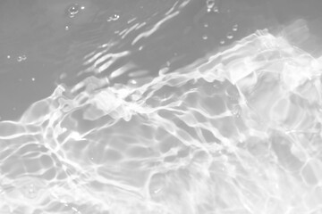 White water with ripples on the surface. Defocus blurred transparent white colored clear calm water surface texture with splashes and bubbles. Water waves with shining pattern texture background.