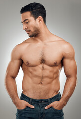 Fototapeta premium Man, body and thinking in studio with abs or muscles, shirtless and grey background with model or bodybuilder. Jeans, strong chest and Asian male person on backdrop, confidence with six pack