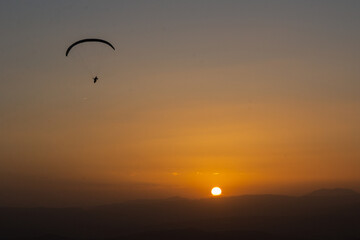 sunrise in the sky and paraglider