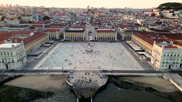 A magnificent aerial view of the central commercial square of the capital of Portugal - Lisbon. Warm sunset light. Tourist center of the old European city. Pra&ccedil;a do Com&eacute;rcio. 4k stock drone video.