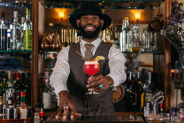 stylish black bartender offering a customer a cocktail