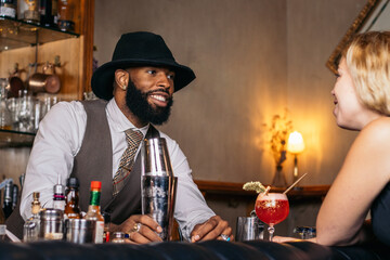 stylish black bartender offering a customer a cocktail