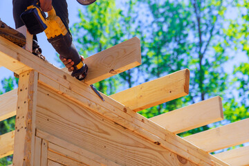 During construction, contractor uses cordless reciprocating saw to cut beams