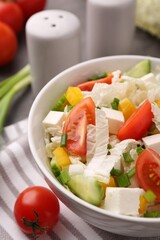 Tasty salad with Chinese cabbage, cheese, pepper, tomato and green onion on table, closeup
