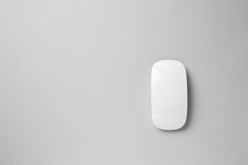 One wireless mouse on grey background, top view. Space for text