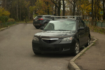 Naklejka premium A car in a parking lot in the city. Transport in the yard. A parked car on the street.