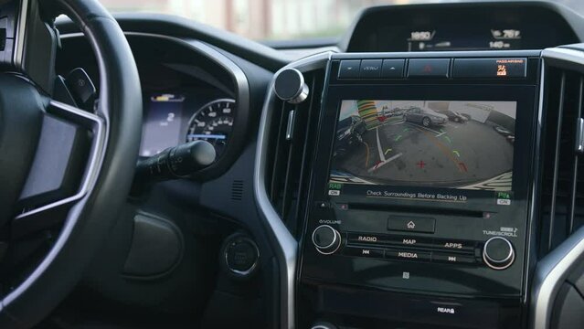 Closeup of display with image reverse parking. Maneuvering between two parked cars